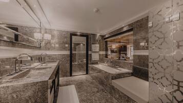 A modern bathroom with a marble floor, a double sink vanity, a bathtub, and a large mirror.
