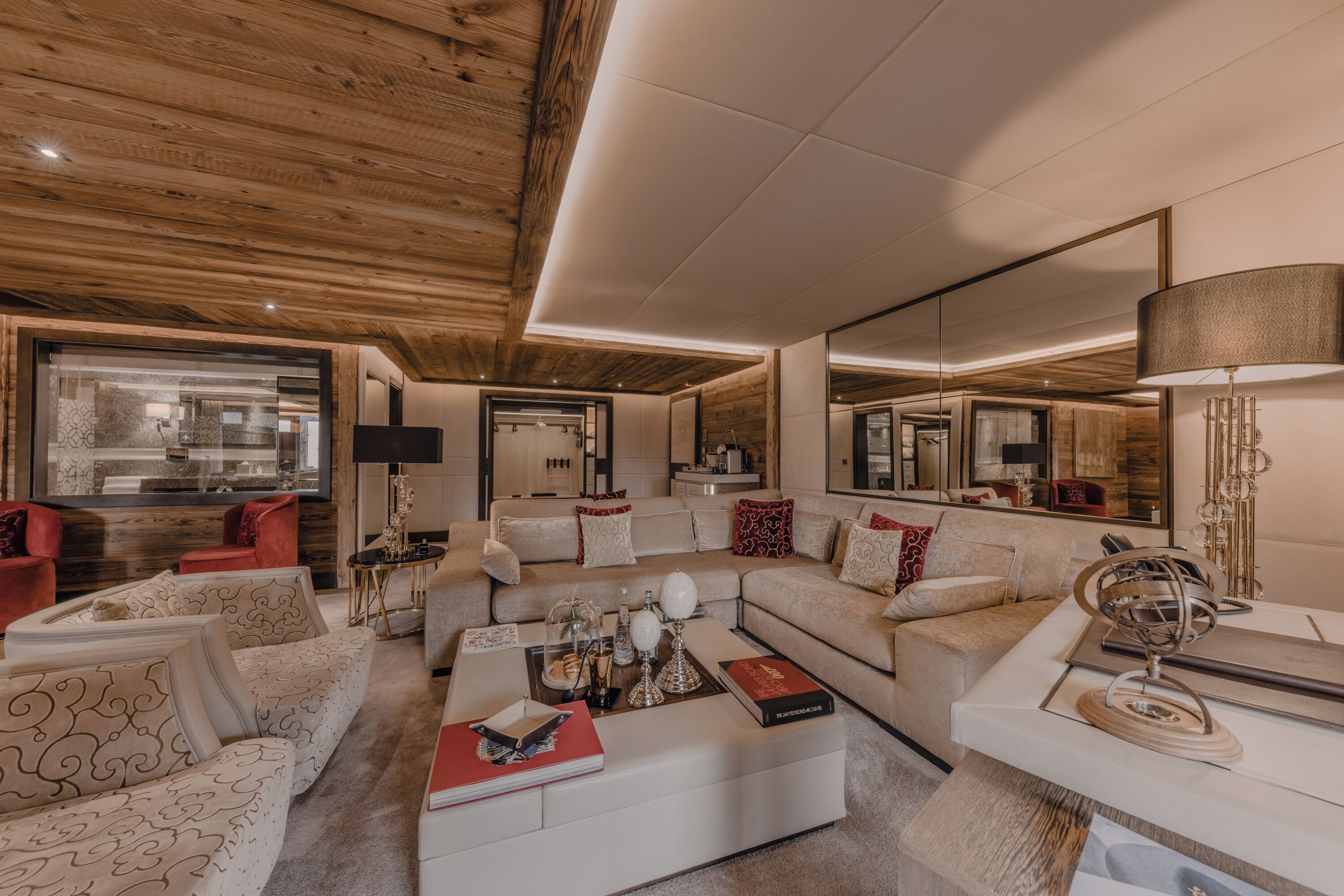 A modern living room with a wooden ceiling, a large mirror, and a sofa set.