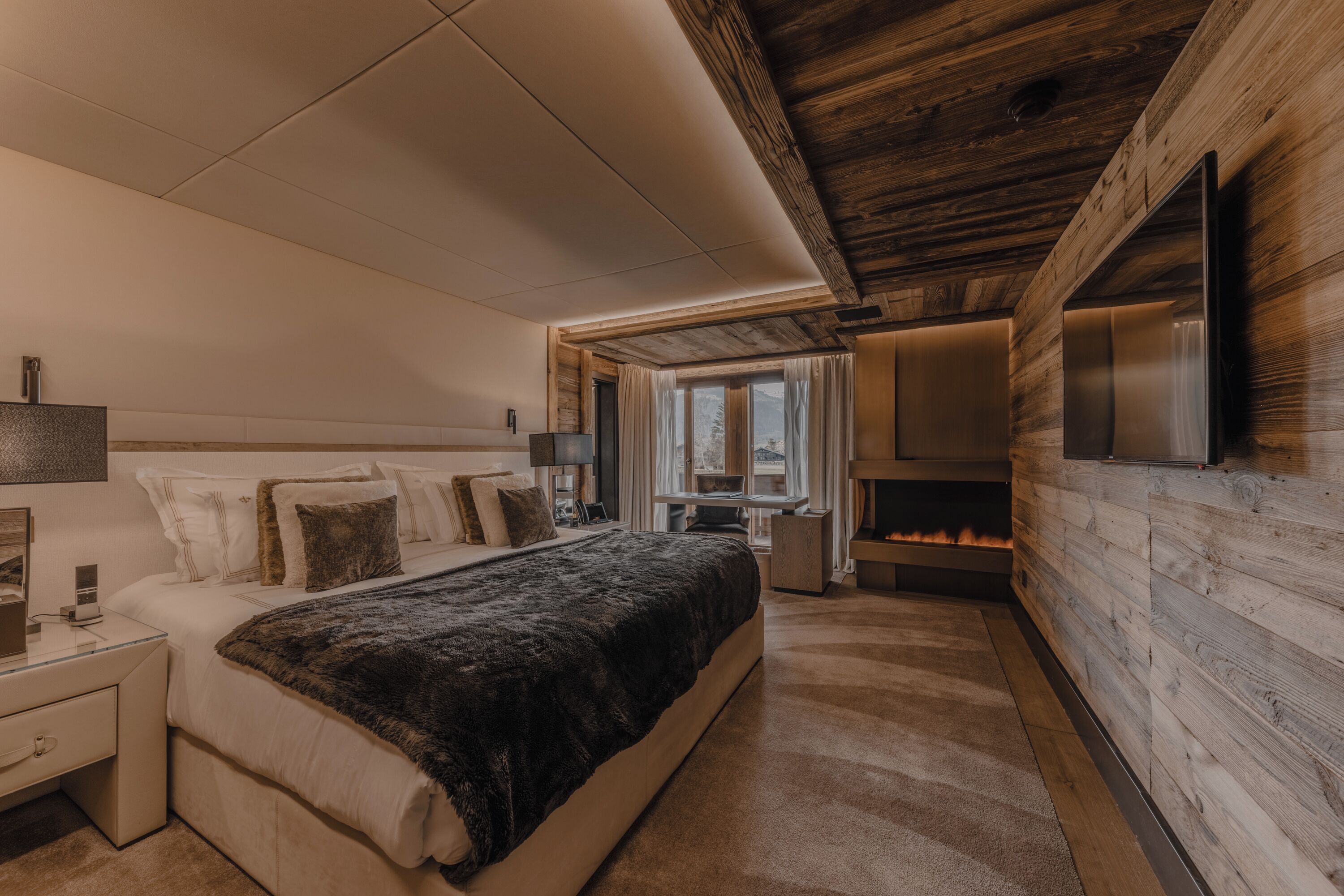 Un dormitorio con cama, mesita de noche, lámpara y chimenea.