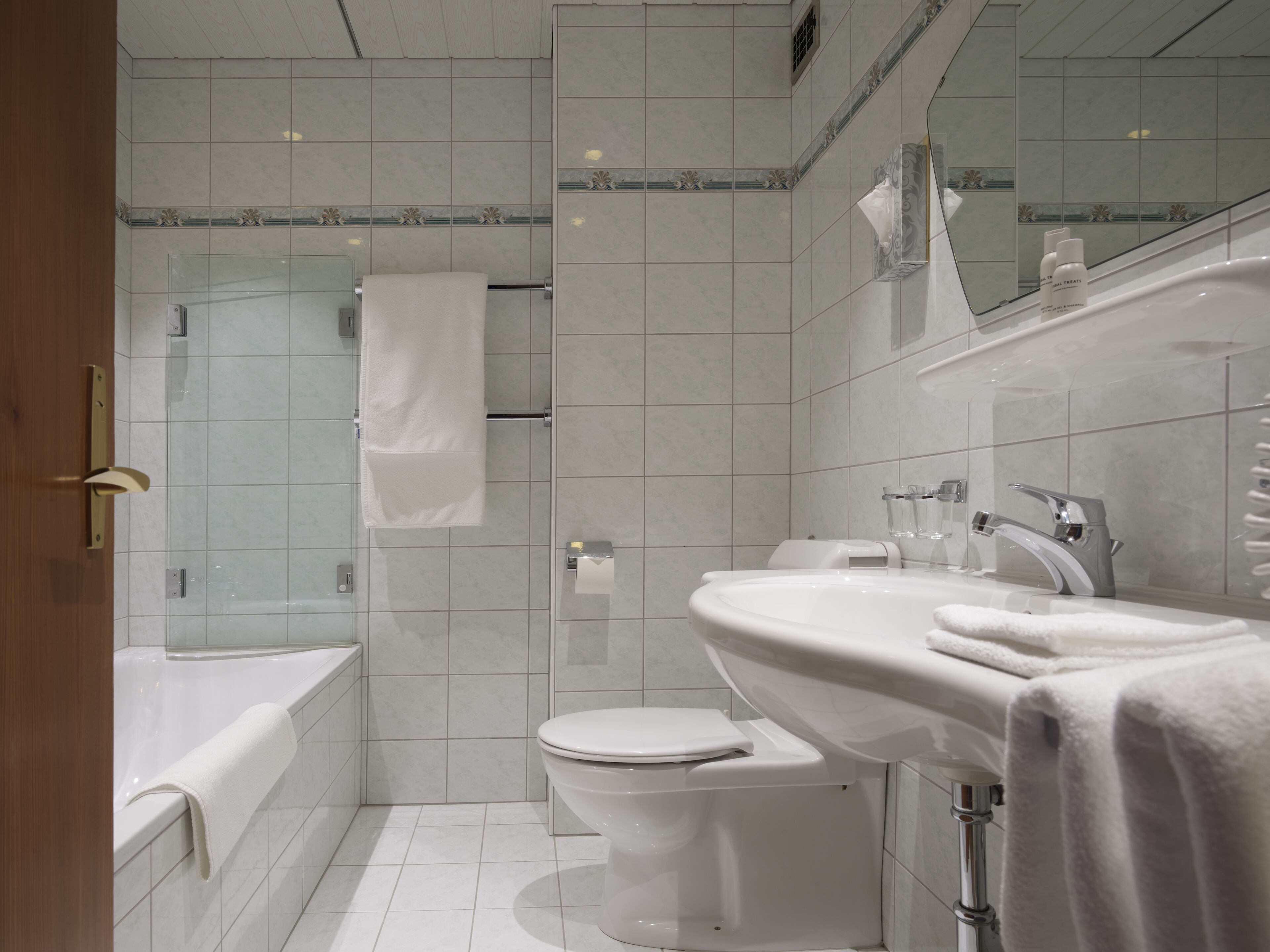 A modern bathroom with a bathtub, toilet, and sink.