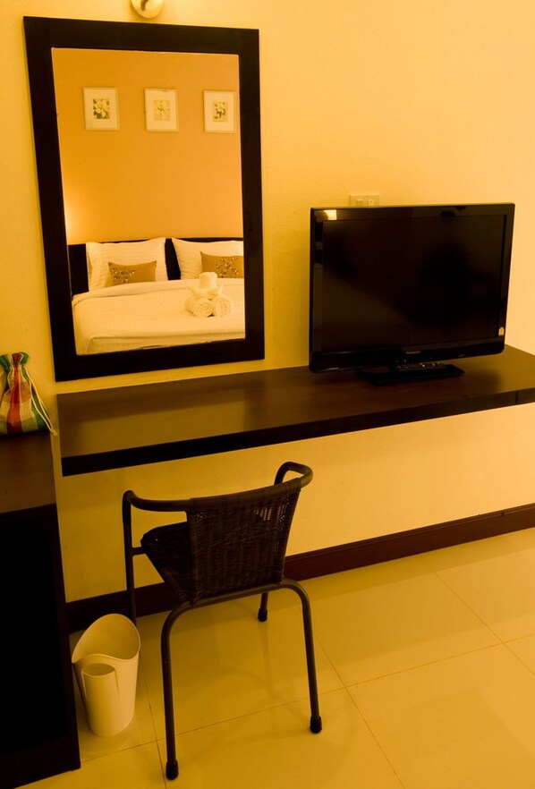 A hotel room with a bed, a television, a chair, and a mirror.