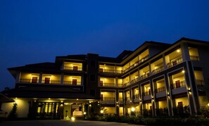 A multi-story hotel with balconies and a covered entrance.