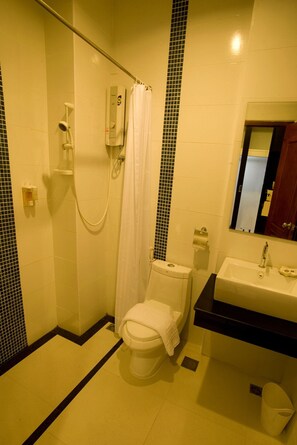 Un baño con ducha, inodoro, lavabo y espejo.