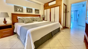 A neatly arranged bedroom with a large bed, bedside tables, a wardrobe, and a ceiling light.
