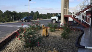 Un estacionamiento con una estatua de una figura dorada, una pequeña estatua de elefante y un letrero de Dr Pepper.