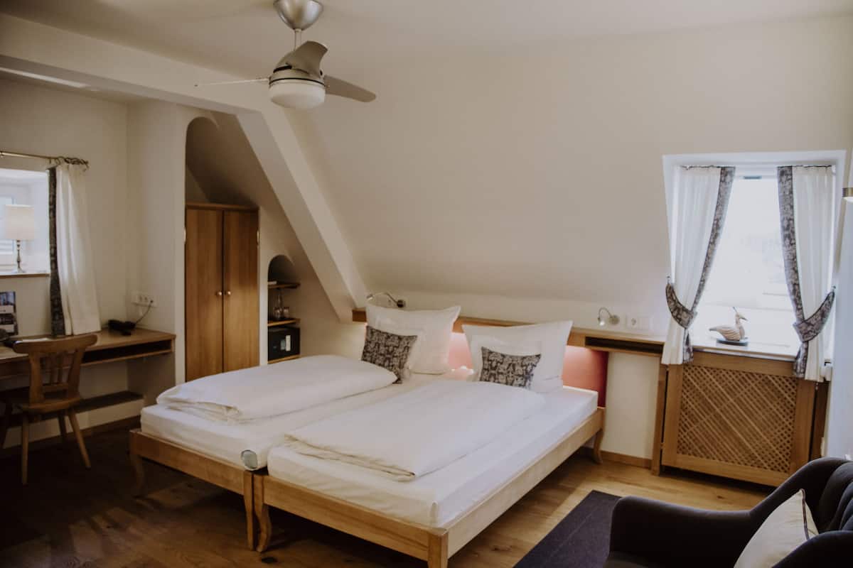 A bedroom with a double bed, a desk, and a chair.