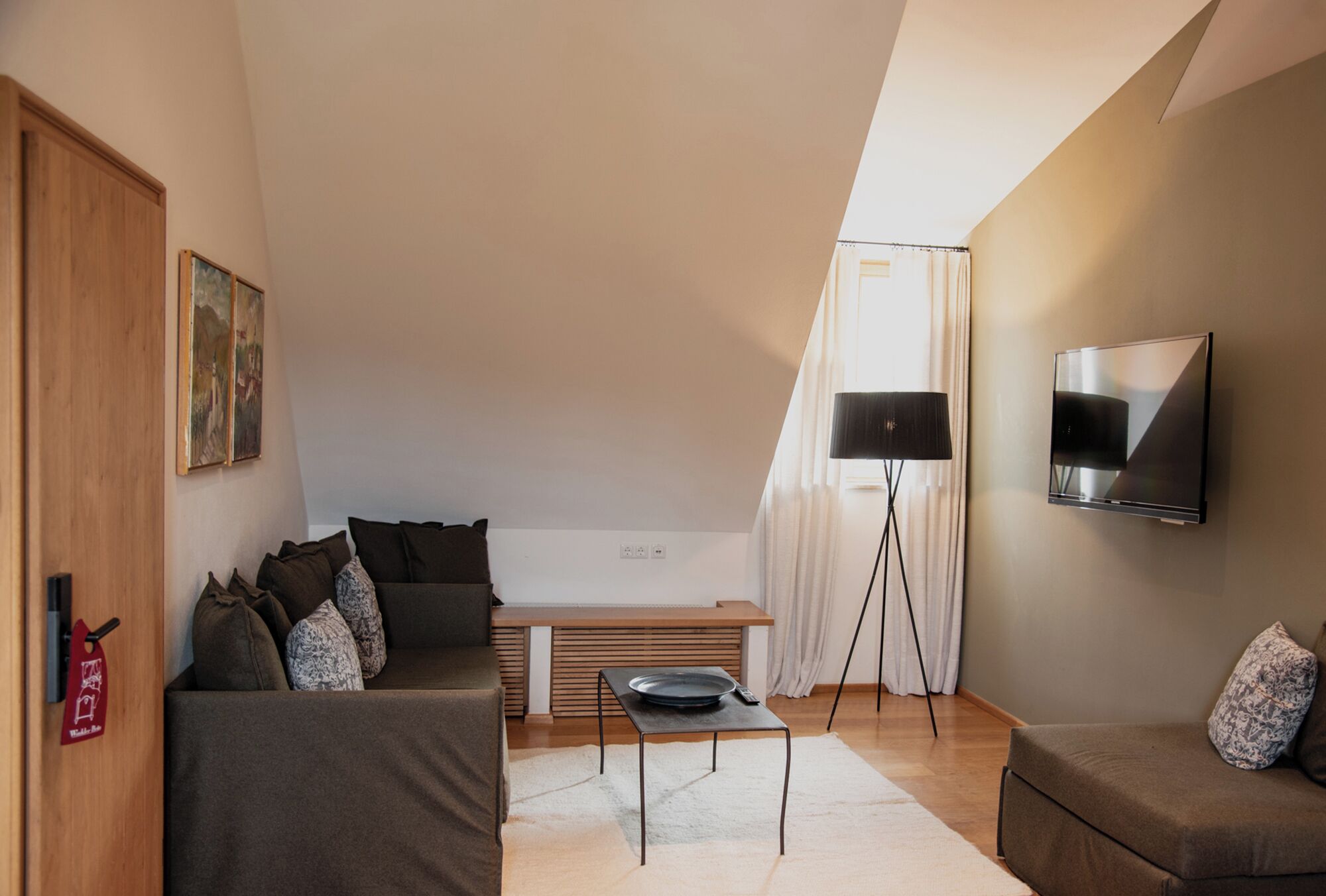 A modern living room with a sofa, a coffee table, a TV, and a painting on the wall.
