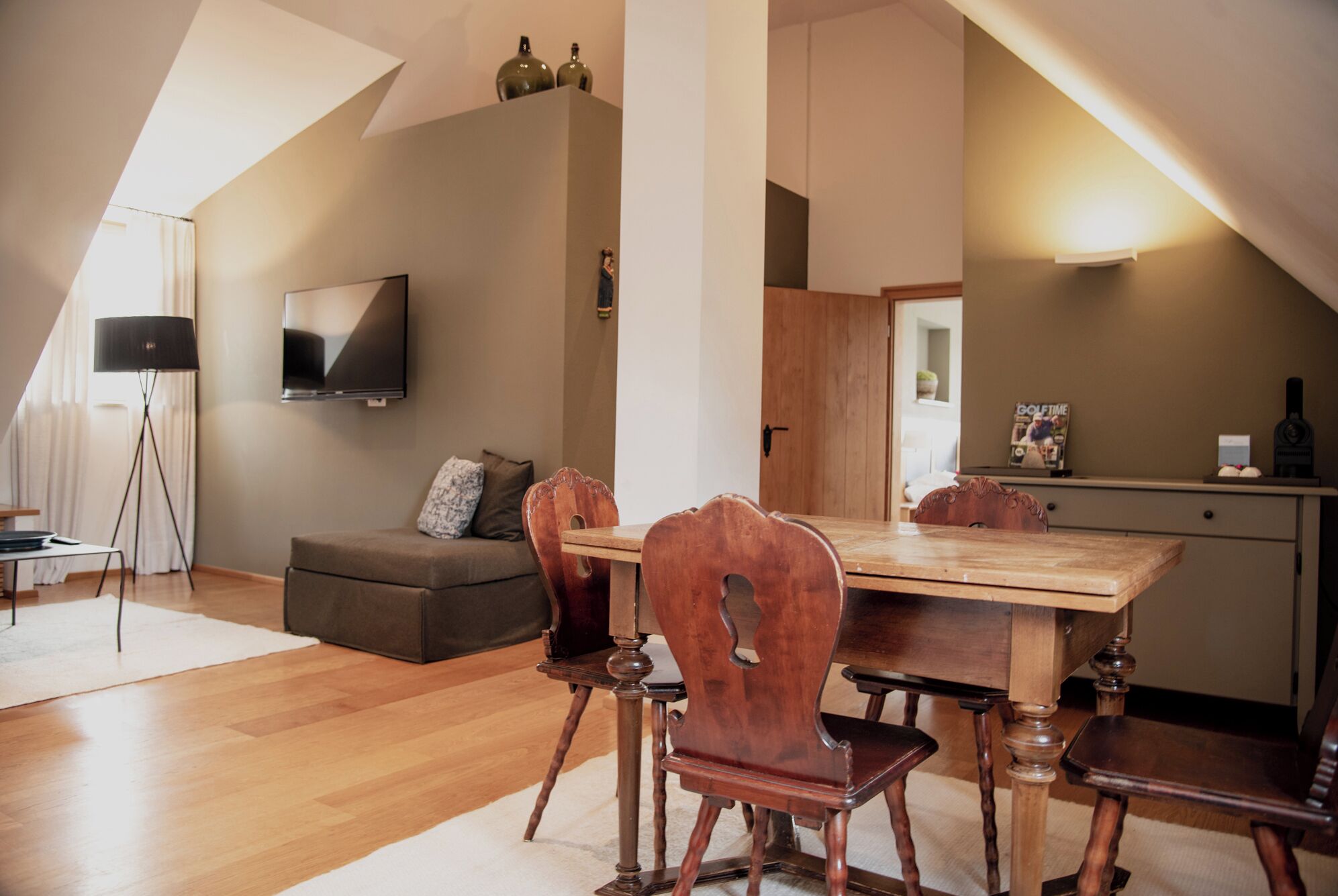 Um apartamento loft moderno com área de jantar, sofá, TV e cozinha.