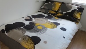 A bedroom with a bed featuring a black and white abstract design, a round mirror on the wall, and a framed picture above the bed. - City Centre Belfast (Belfast)