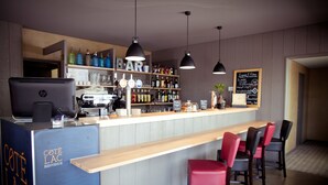 Eine Bar mit einer Theke, Barhocker, Flaschenregalen und einer Kreidetafel-Speisekarte.