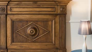 A wooden cabinet with intricate carvings and a blue table beside it.
