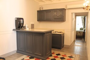 Una cocina con una isla de madera oscura, una cafetera y una estufa.