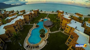 A resort with multiple buildings, a central swimming pool, and a view of the ocean. - Las Glorias LG307 3 Bedroom Apartment By Seaside San Carlos (San Carlos)