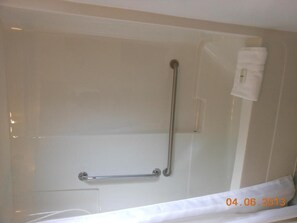 A bathroom with a shower area, grab bars, and a towel rack. - Mountain Springs Motel & RV Park (Barriere)