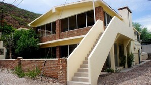 A two-story house with a brick facade, large windows, and a staircase leading to the upper floor. - Bahia 189 Bottom Chip s Place 1 Bedroom Apartment By Seaside San Carlos (San Carlos)