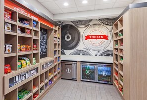 Un espacio para refrigerios con estantes llenos de diferentes opciones y una sección refrigerada.