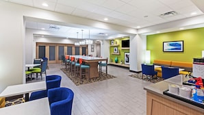A hotel lobby with a dining area, seating, and a reception desk. - Hampton Inn Ozona (Ozona)