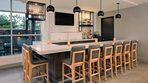 A modern kitchen with a large island, bar area, and seating.
