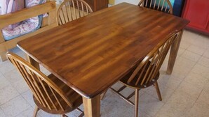 A wooden dining table with four chairs, a bench, and a kitchen area with a red cabinet. - Caracol Peninsula 544 A 2 Bedroom Apartment By Seaside San Carlos (San Carlos)