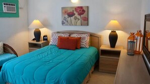 A bedroom with a bed, two bedside tables, lamps, a painting, and a nightstand. - Caracol Peninsula 544 A 2 Bedroom Apartment By Seaside San Carlos (San Carlos)