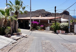 Un edificio con techo de tejas, fachada de piedra y entrada empedrada.