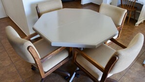 A round table with four chairs, each with a woven seat and wooden frame.
