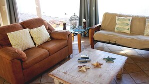 A living room with a brown leather sofa, a beige sofa, and a wooden coffee table with starfish decorations. - Costa del Mar 57 2 Bedroom Apartment By Seaside San Carlos (San Carlos)