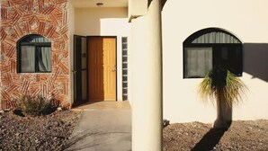 A modern building with a patterned facade, a wooden door, and two arched windows. - Costa del Mar 57 2 Bedroom Apartment By Seaside San Carlos (San Carlos)