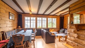 L’intérieur d’un chalet confortable, avec une salle à manger, un coin salon et une cheminée.