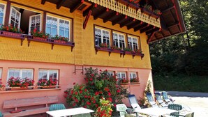 Un chalet traditionnel doté d’un balcon en bois, de jardinières et d’un espace salon extérieur.