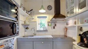 A kitchen with a microwave, oven, sink, and various utensils. - Holiday home in Krabbendam (Krabbendam)