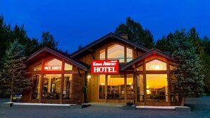Un hotel con un letrero llamativo que dice "Kenai Airport Hotel" y un letrero de "Habitación disponible".