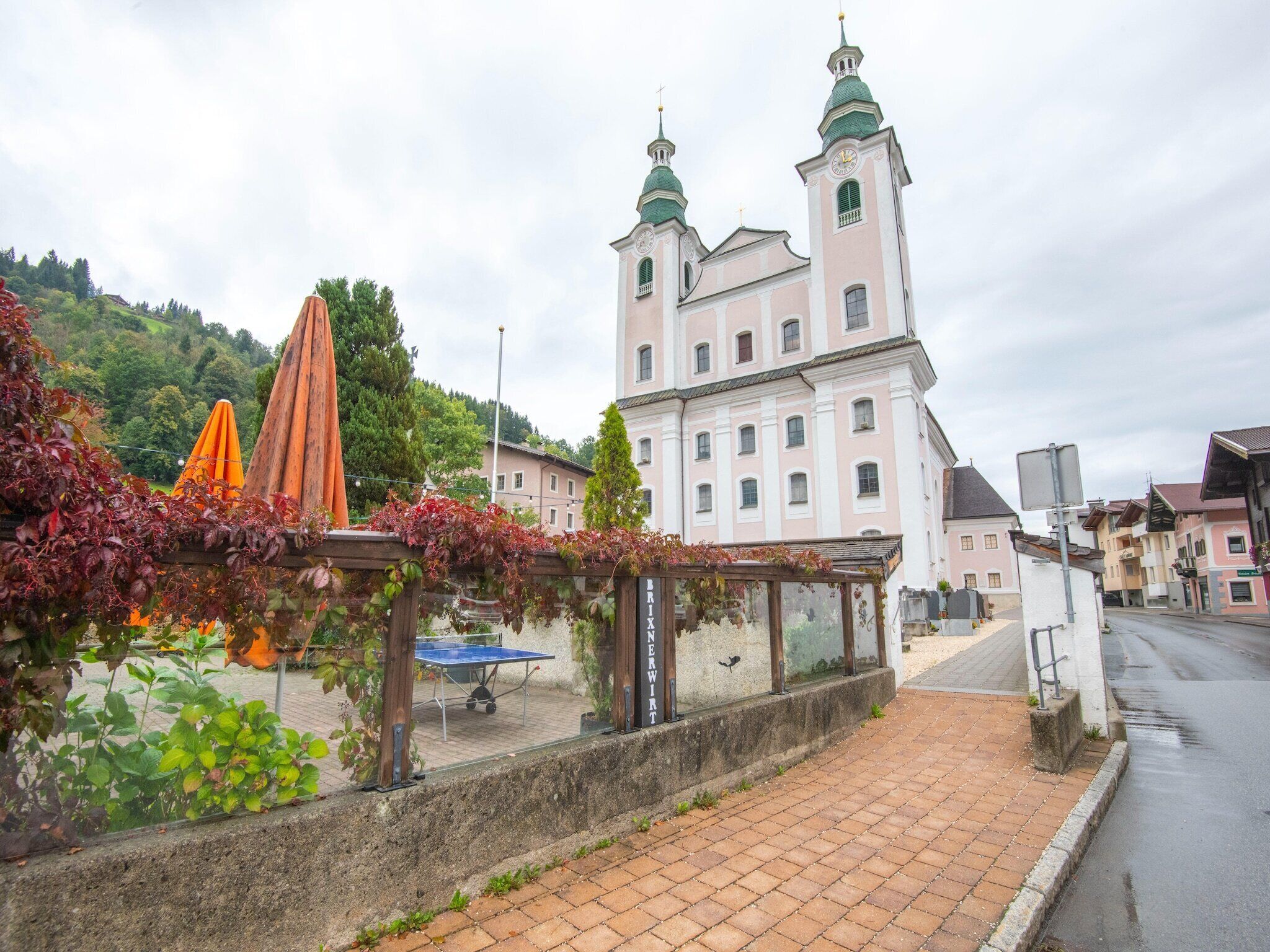 A historic building with two towers and a paved walkway in front.