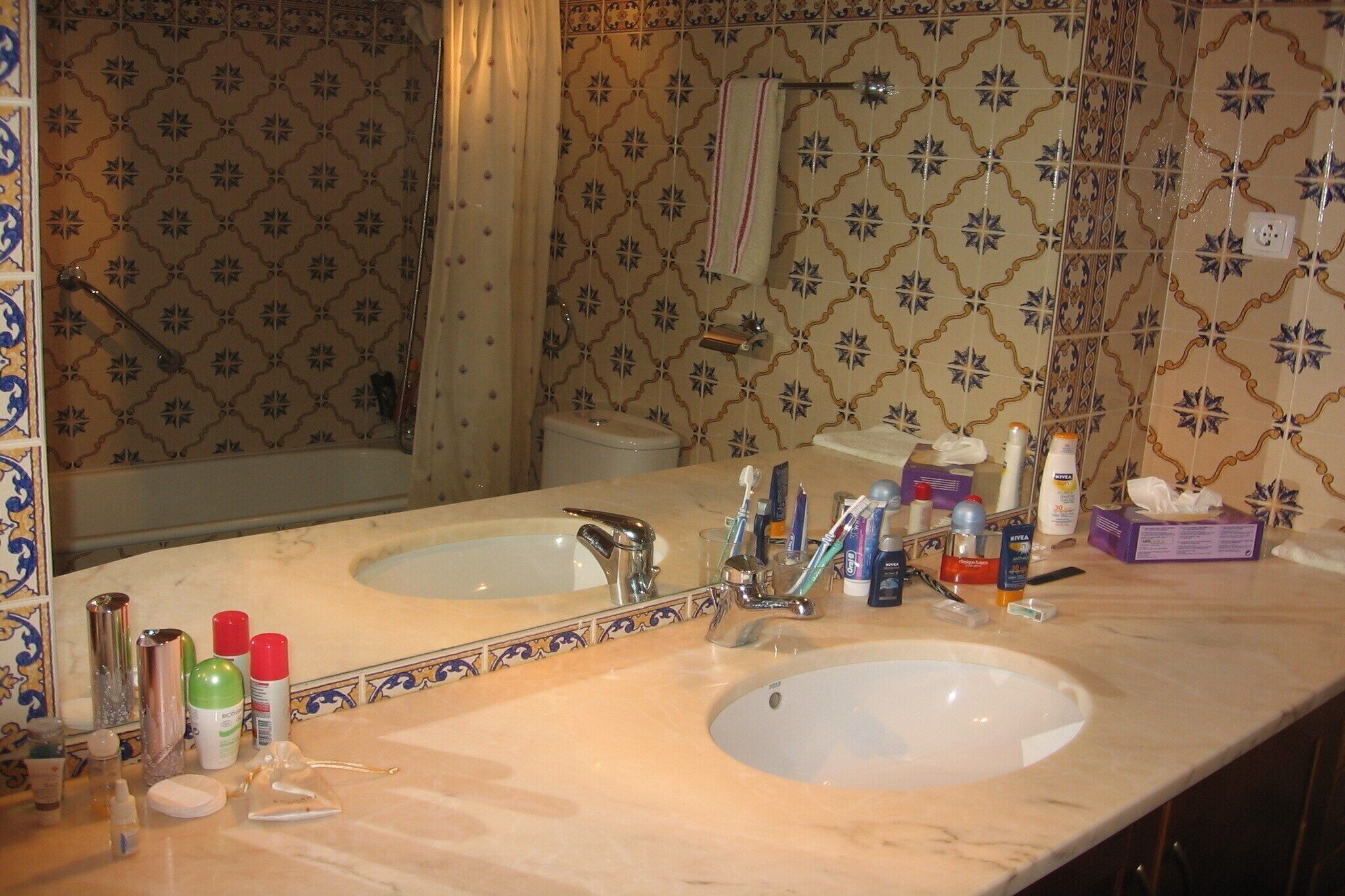 A bathroom with two sinks, a large mirror, and a shower area.