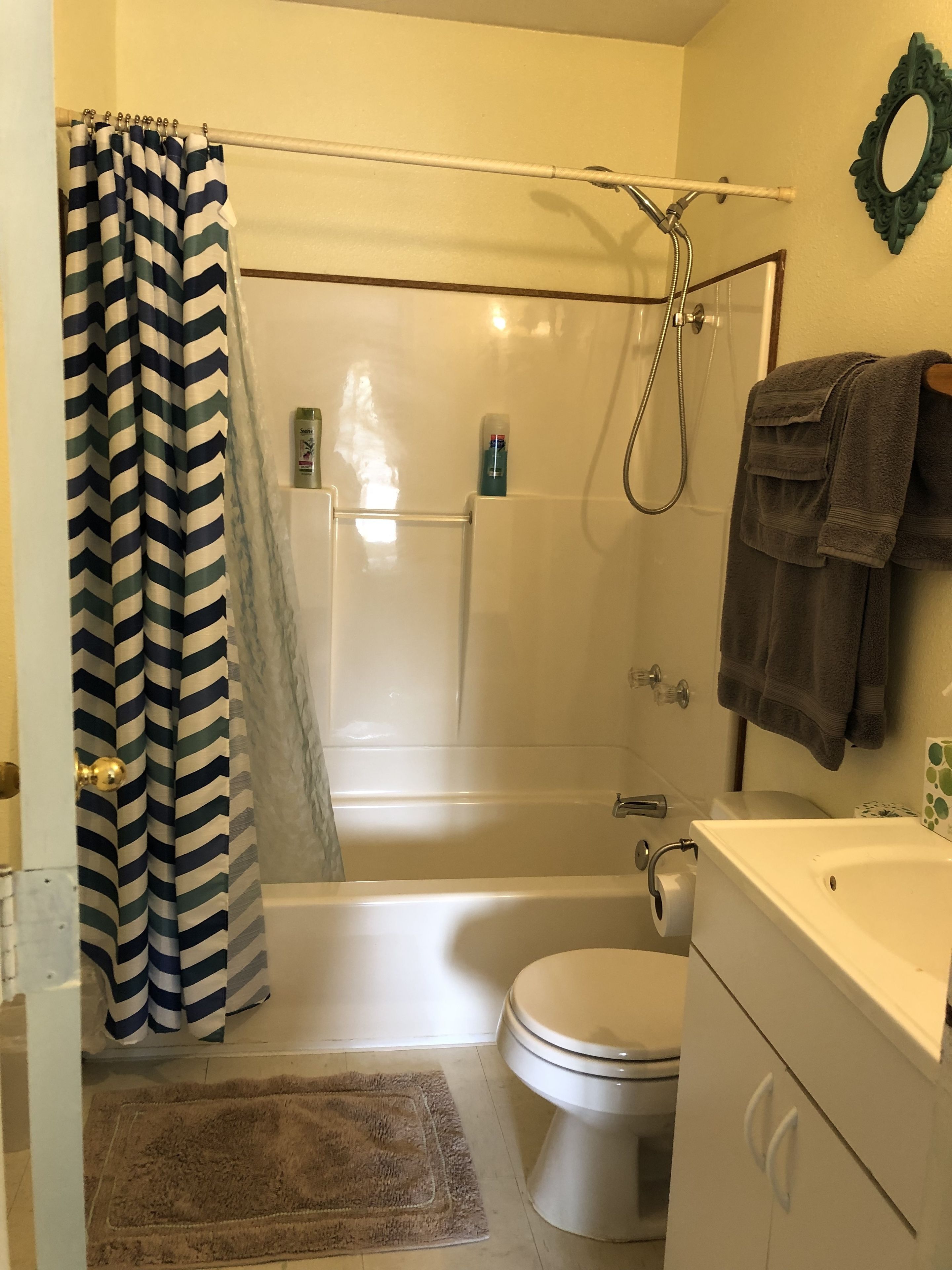 A bathroom with a shower, toilet, and sink.