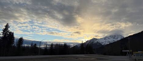 A road leading to a gas station with a mountain backdrop.