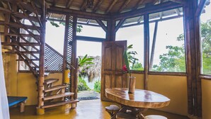 Una escalera de madera que lleva a un balcón con vistas a zonas verdes.