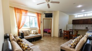 Una sala de estar con dos sofás, un comedor y una cocina.