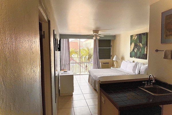 Suite Deluxe, cocineta, vista al patio | Tabla de planchar con plancha, wifi gratis y ropa de cama