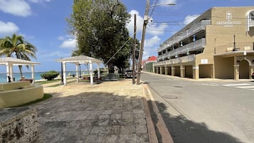Une rue bordée d’un belvédère, de bancs et d’un bâtiment portant l’inscription « The Frederiksted Hotel ».
