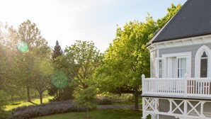 A house with a white exterior, a balcony, and a well-maintained garden with a hedge maze. - The Marlborough (Rapaura)