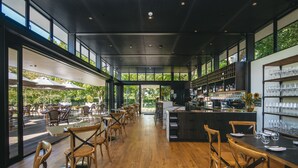 A spacious restaurant with wooden flooring, large windows, and a bar area. - The Marlborough (Rapaura)