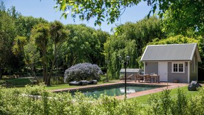 A house with a swimming pool, surrounded by lush greenery and trees. - The Marlborough (Rapaura)