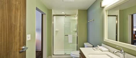 A modern bathroom with a shower, toilet, and dual sinks.