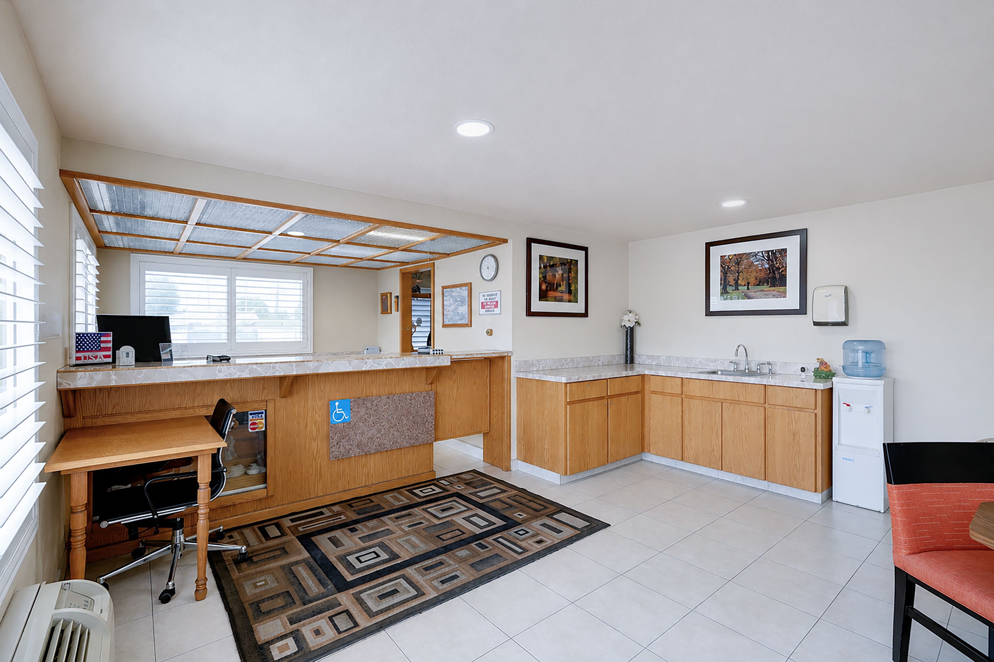 A modern kitchen with wooden cabinets, a built-in dishwasher, and a small refrigerator.