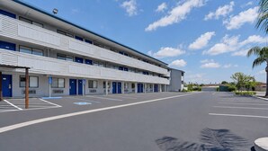 Un hôtel à plusieurs étages, doté d’un parking et offrant une vue sur un ciel dégagé.