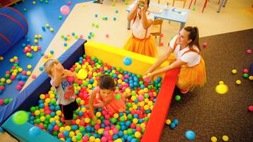 A play area with colorful balls and a soft play surface.