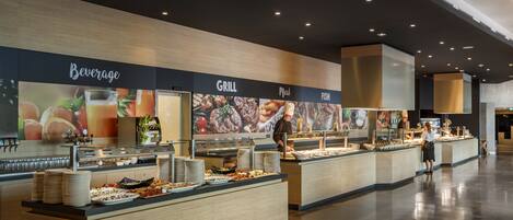 A buffet area with sections for beverages, grill, and fish.