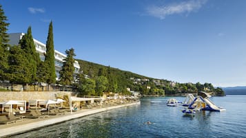 Sable blanc, chaises longues, parasols, serviettes de plage