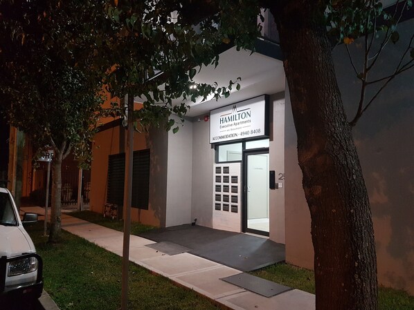 A building with a sign for Hamilton Executive Apartments.